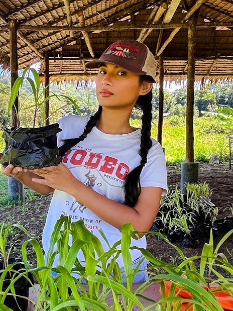 Woman holding corn plant at Bukit Elephant Park.
