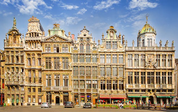 Ornate guildhalls in Brussels' Grand Place under a blue sky.