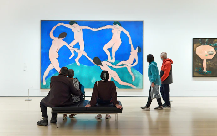 Tourists viewing modern art paintings at The Museum of Modern Art.
