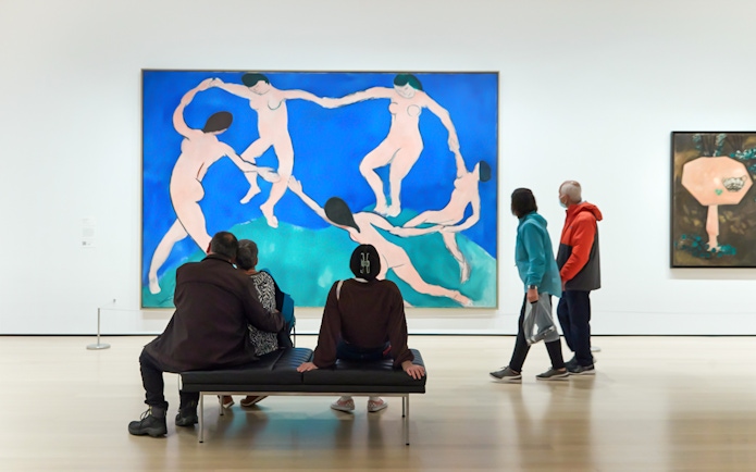 Tourists viewing modern art paintings at The Museum of Modern Art.