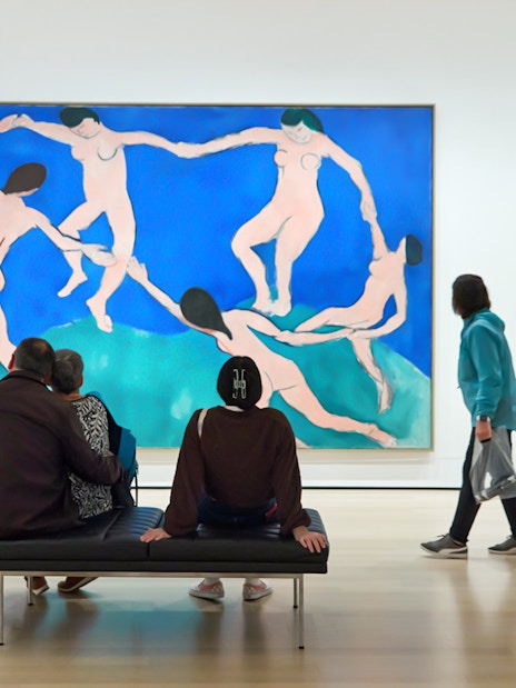 Tourists viewing modern art paintings at The Museum of Modern Art.