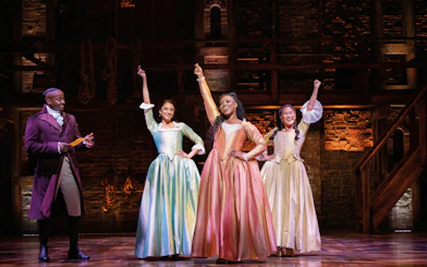 Performers on stage during Hamilton musical in West End theater.