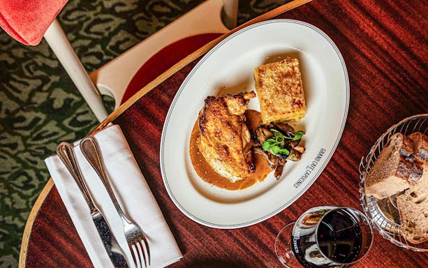 Roasted chicken with sauce, gratin, and mushrooms at Grand Café Capucines, Paris.