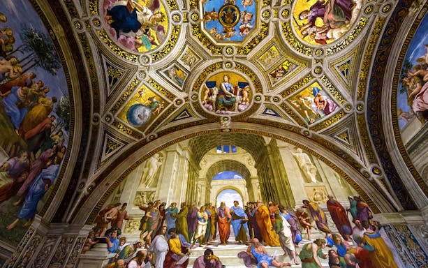 Raphael's School of Athens fresco in Vatican City, depicting philosophers under ornate ceiling.