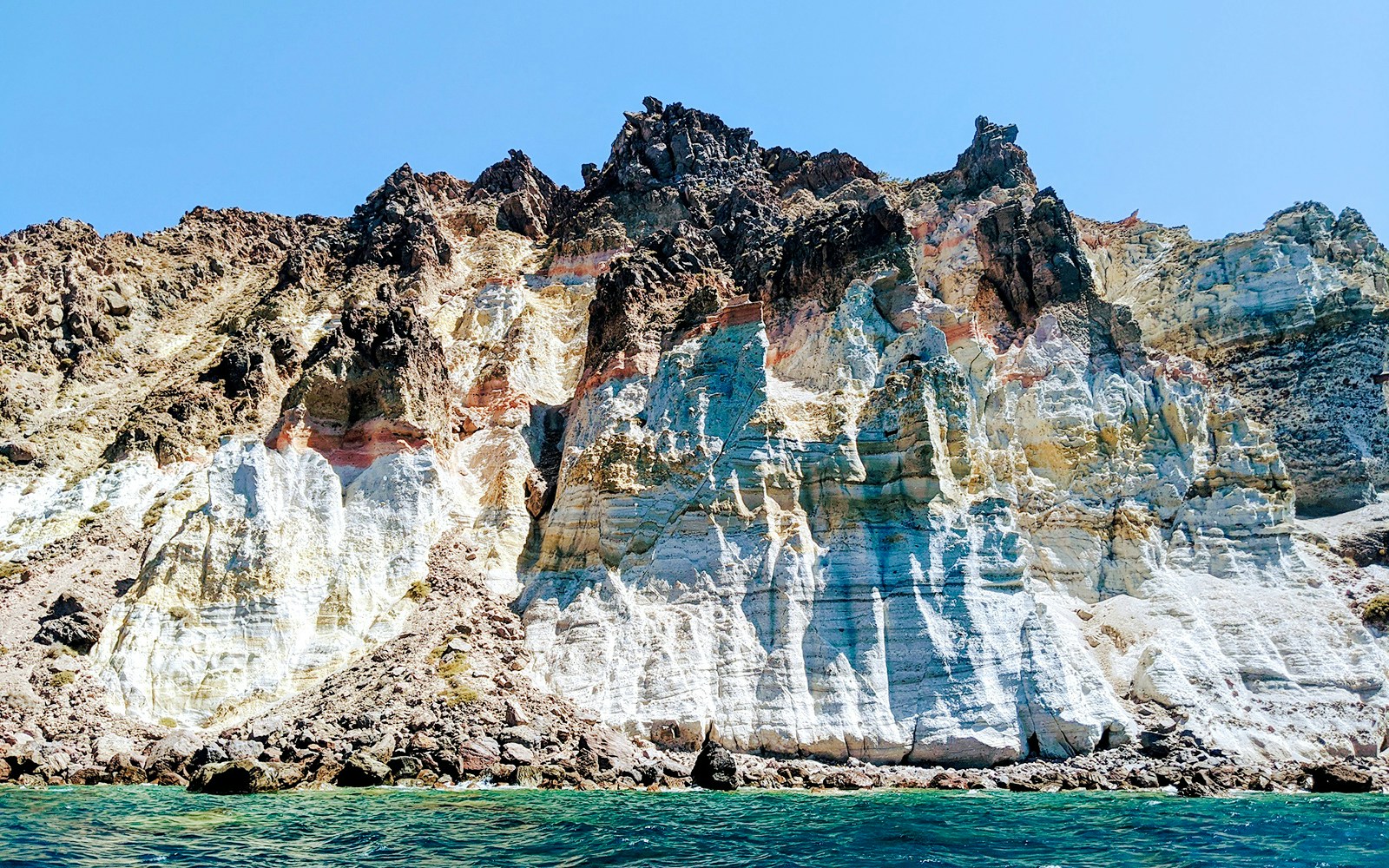 Volcanic cliffs of the Santorini caldera, Greece, viewed from the sea.