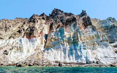 Volcanic cliffs of the Santorini caldera, Greece, viewed from the sea.