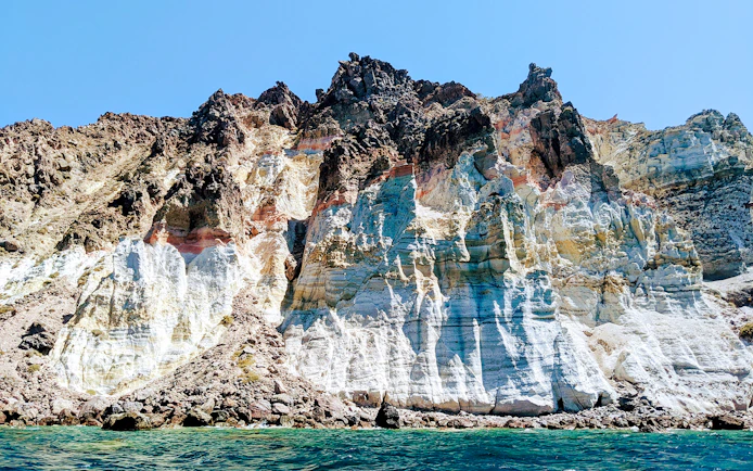 Volcanic cliffs of the Santorini caldera, Greece, viewed from the sea.