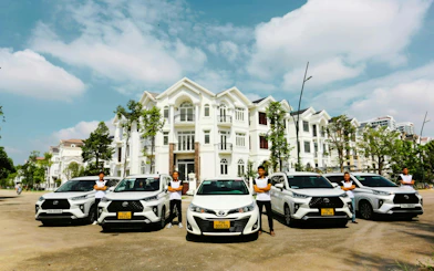 Chauffeurs standing by cars in front of a villa for Hue to Da Nang private car tour via Hai Van Pass.