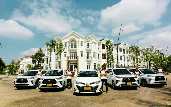 Chauffeurs standing by cars in front of a villa for Hue to Da Nang private car tour via Hai Van Pass.