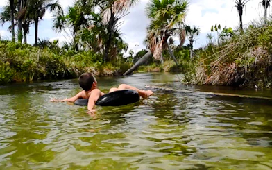 Tubing in Cardosa river surrounded by lush greenery, Barreirinhas, Sao Paulo.