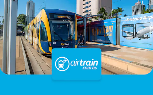 Brisbane Airtrain at station with city skyline in background.