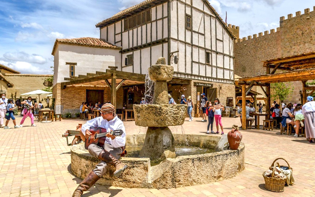 Guitarist performing near a fountain at Puy du Fou España park.