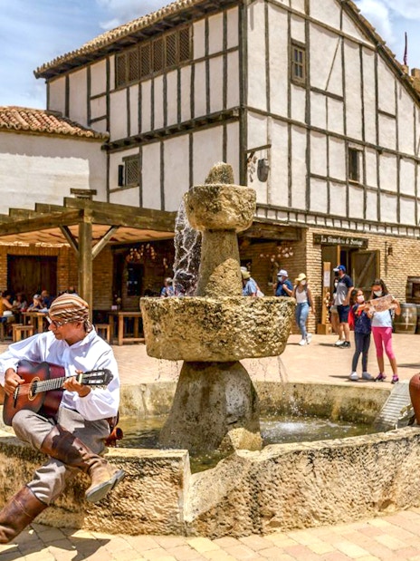 Guitarist performing near a fountain at Puy du Fou España park.