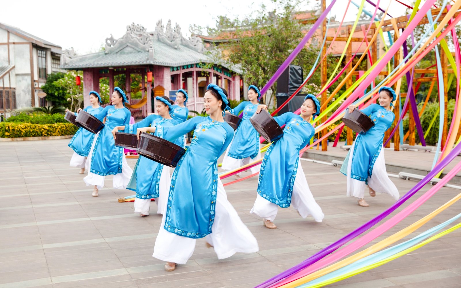 Performers in traditional blue attire dancing at Hoi An Memories Show, Vietnam.