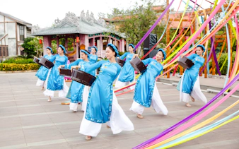 Performers in traditional blue attire dancing at Hoi An Memories Show, Vietnam.