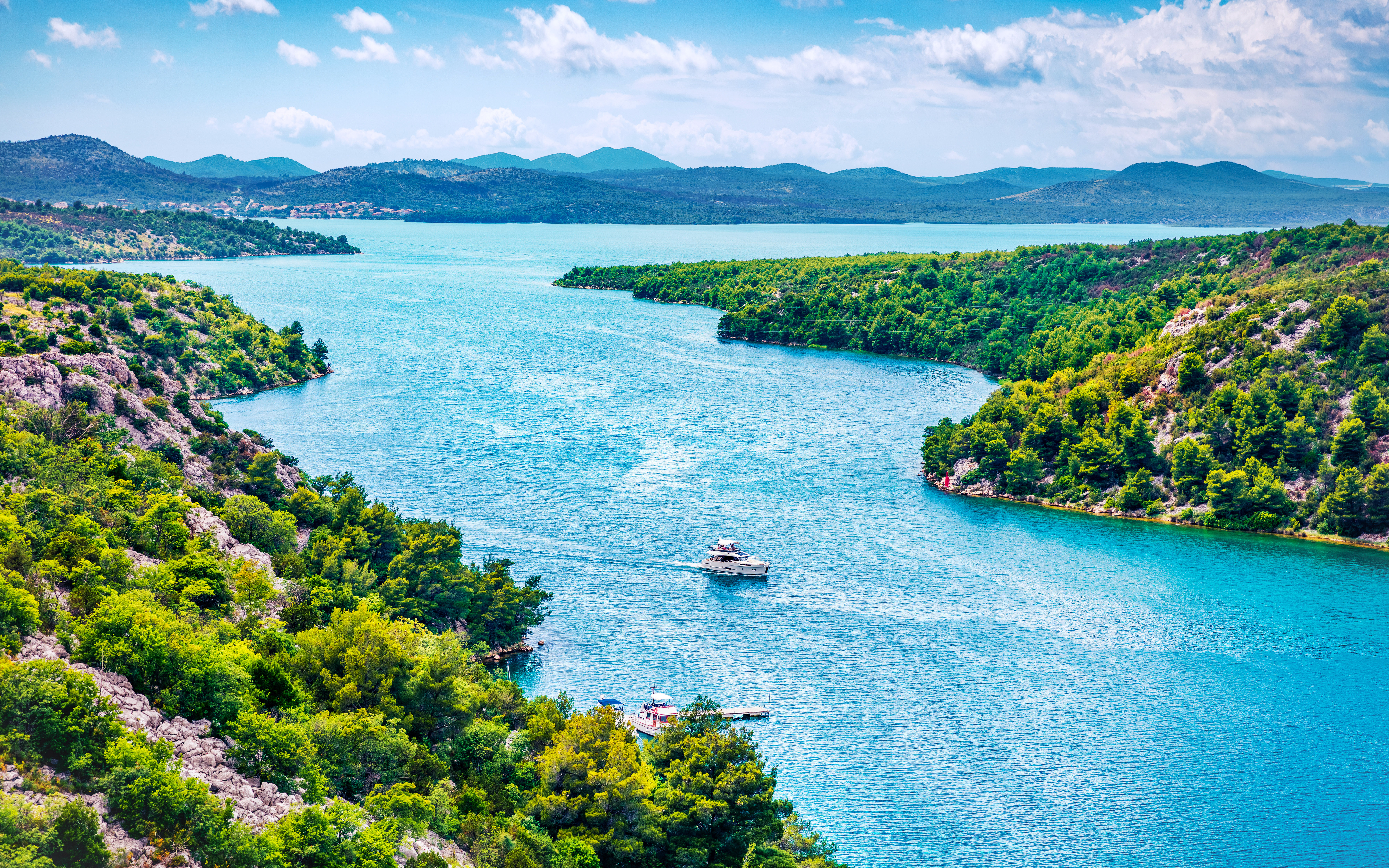 Aerial view of Prokljansko Lake in Krka National Park, Croatia, with boats on the water.