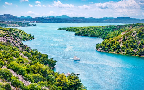 Aerial view of Prokljansko Lake in Krka National Park, Croatia, with boats on the water.