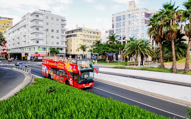 Las Palmas hop-on hop-off bus at city stop with tourists exploring nearby attractions.