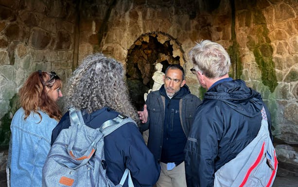 Tourists with guide inside Quinta da Regaleira's grotto, Sintra, Portugal.