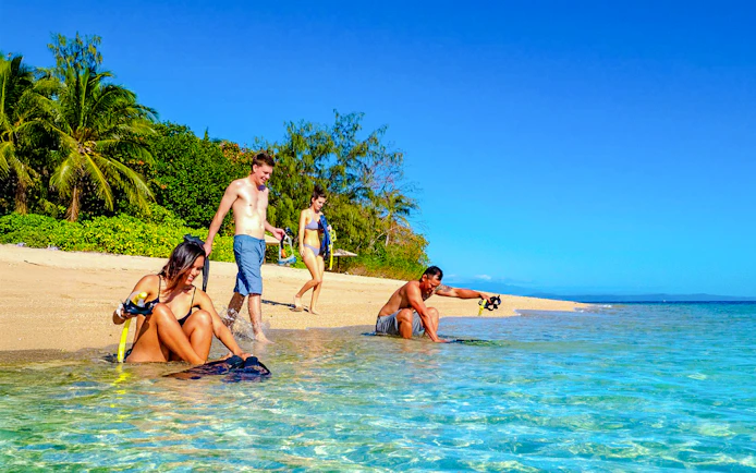Snorkelers preparing on Low Isles beach, Port Douglas cruise.