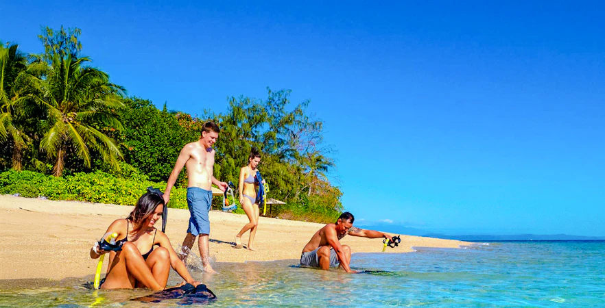 Snorkelers preparing on Low Isles beach, Port Douglas cruise.