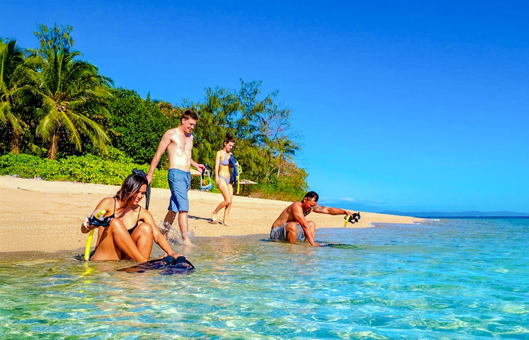 Snorkelers preparing on Low Isles beach, Port Douglas cruise.