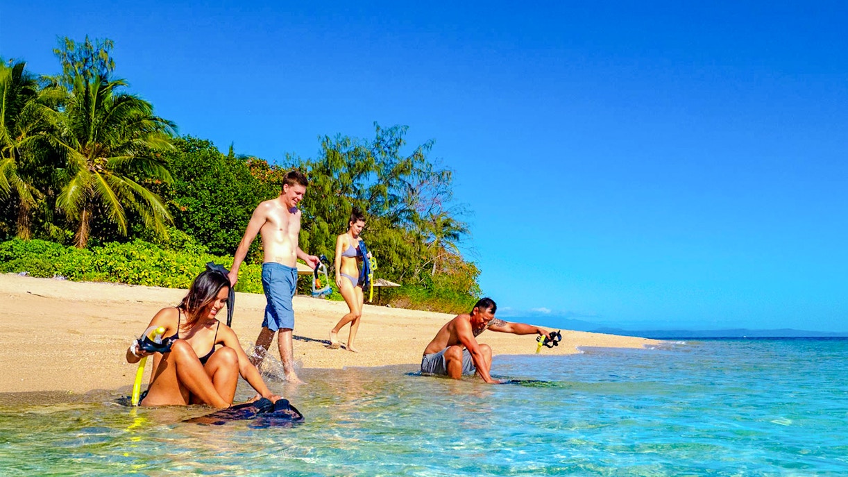 Snorkelers preparing on Low Isles beach, Port Douglas cruise.