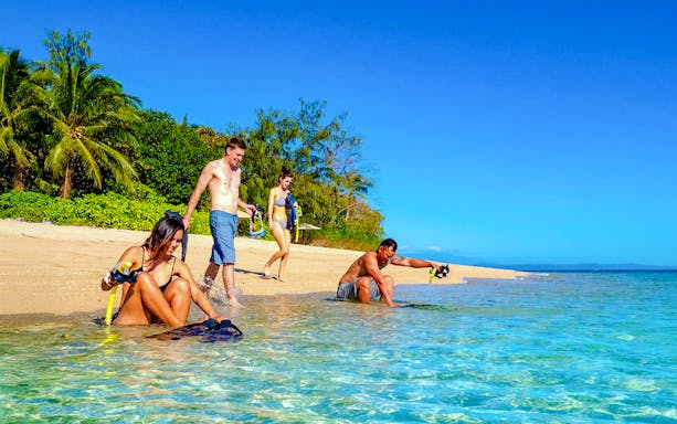Snorkelers preparing on Low Isles beach, Port Douglas cruise.