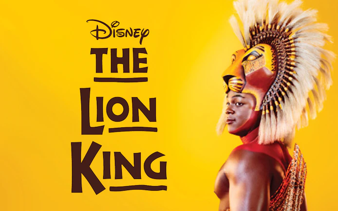 The Lion King performer in costume against a yellow background.