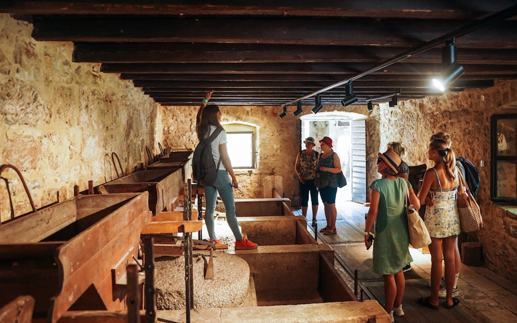 Visitors exploring a historic stone building on the Krka Waterfalls Tour from Split.