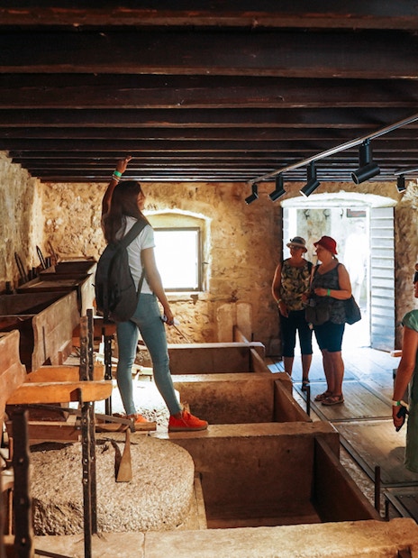 Visitors exploring a historic stone building on the Krka Waterfalls Tour from Split.