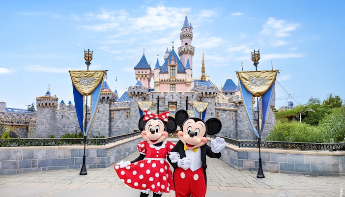 Mickey and Minnie Mouse in front of Sleeping Beauty Castle at Disneyland Park, California.