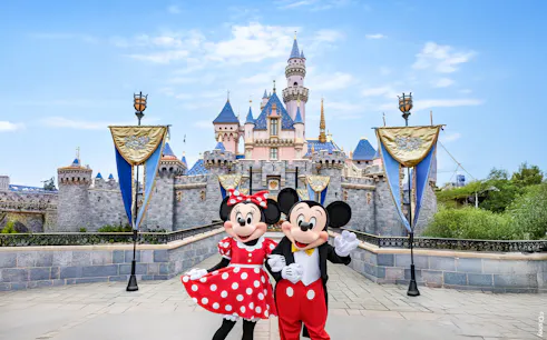Mickey and Minnie Mouse in front of Sleeping Beauty Castle at Disneyland Park, California.