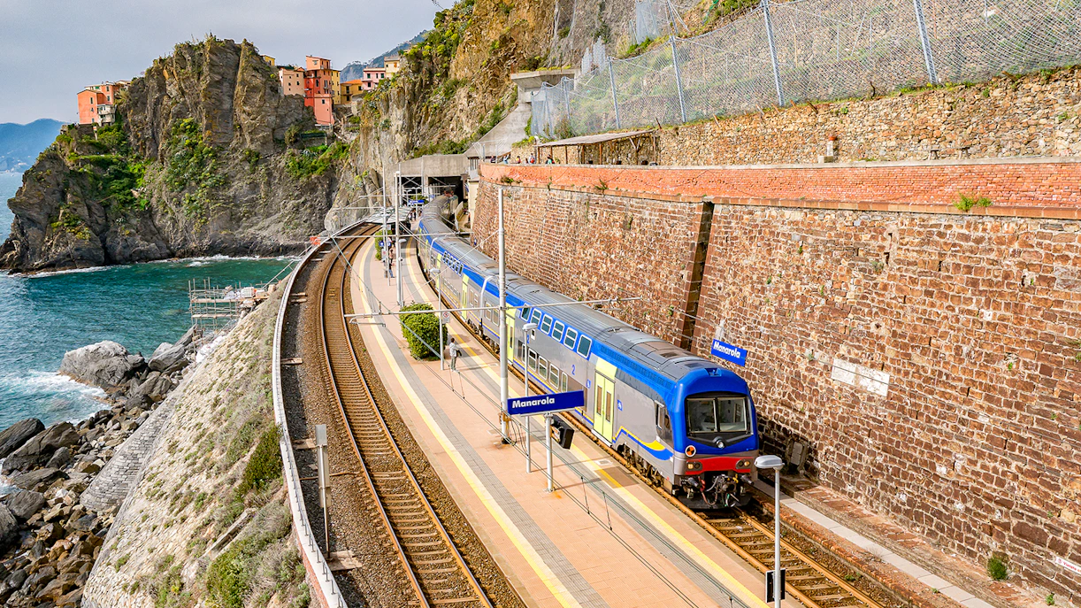Scenic train at Manarola station with coastal cliffs in Cinqueterre, Italy.
