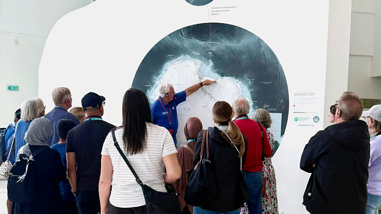 Guide explaining Antarctic map to visitors at the International Antarctic Centre, Christchurch.