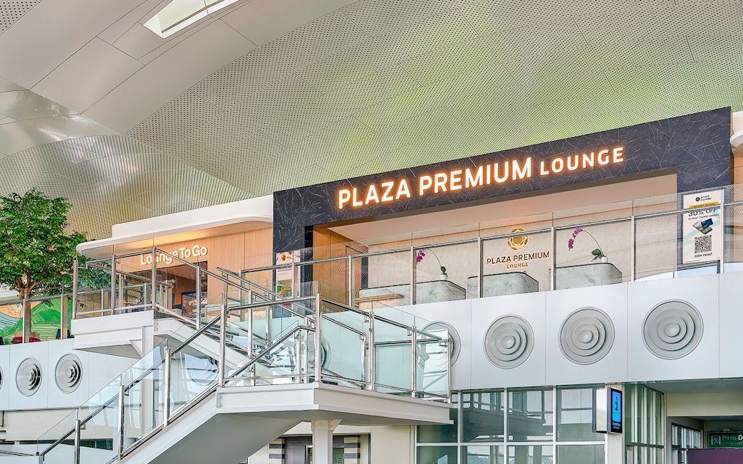 Plaza Premium Lounge exterior with glass railings and signage.
