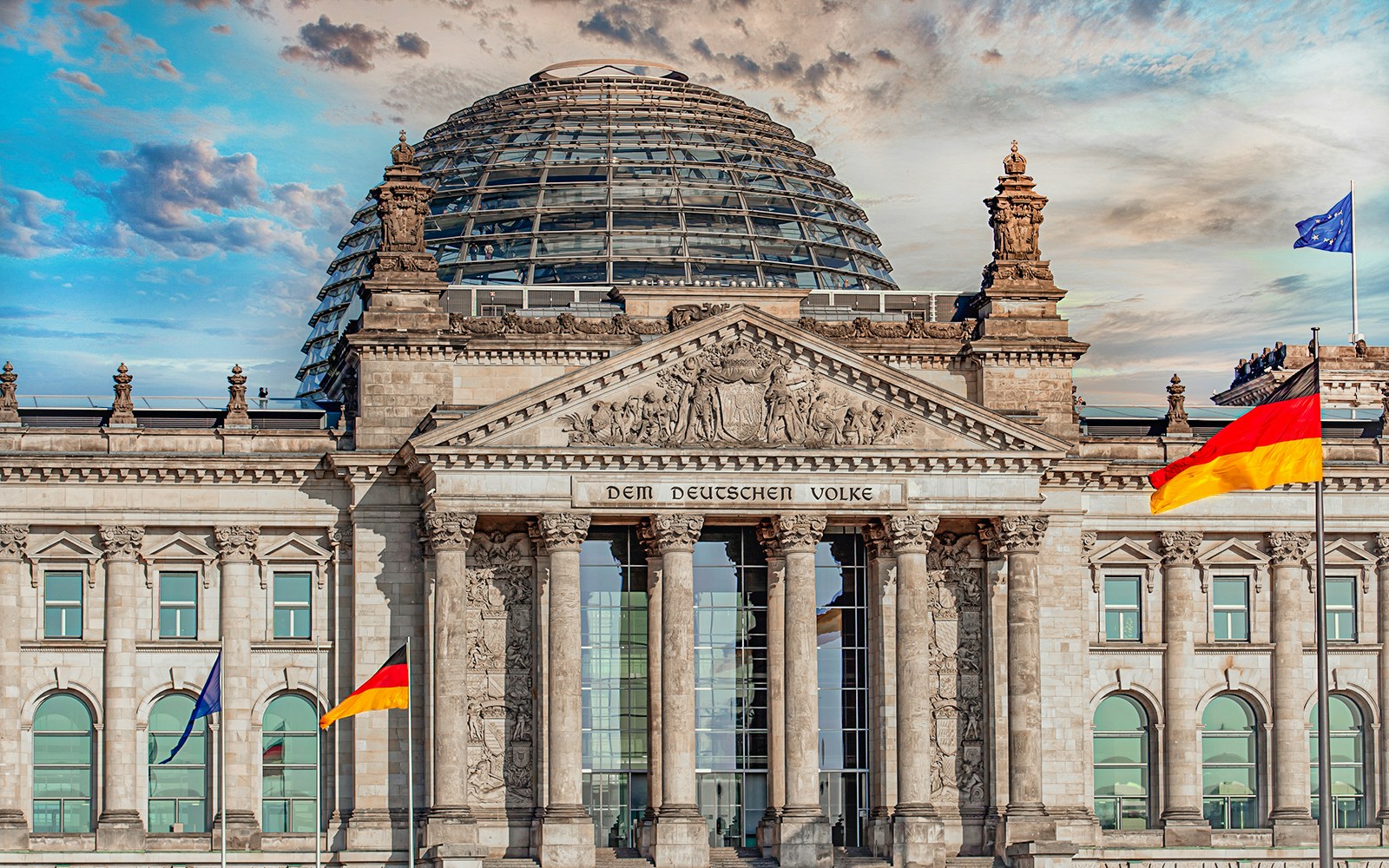 Reichstag building in Berlin with glass dome and German flag.