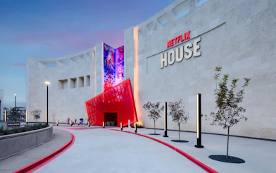 Netflix House entrance with vibrant red canopy and mural, Dallas.