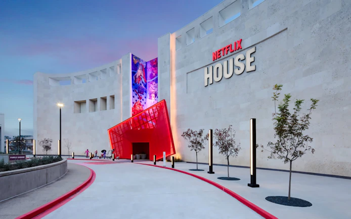 Netflix House entrance with vibrant red canopy and mural, Dallas.