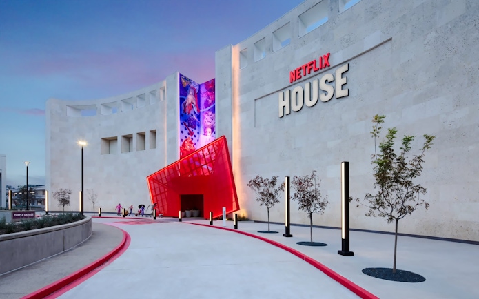 Netflix House entrance with vibrant red canopy and mural, Dallas.
