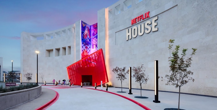 Netflix House entrance with vibrant red canopy and mural, Dallas.