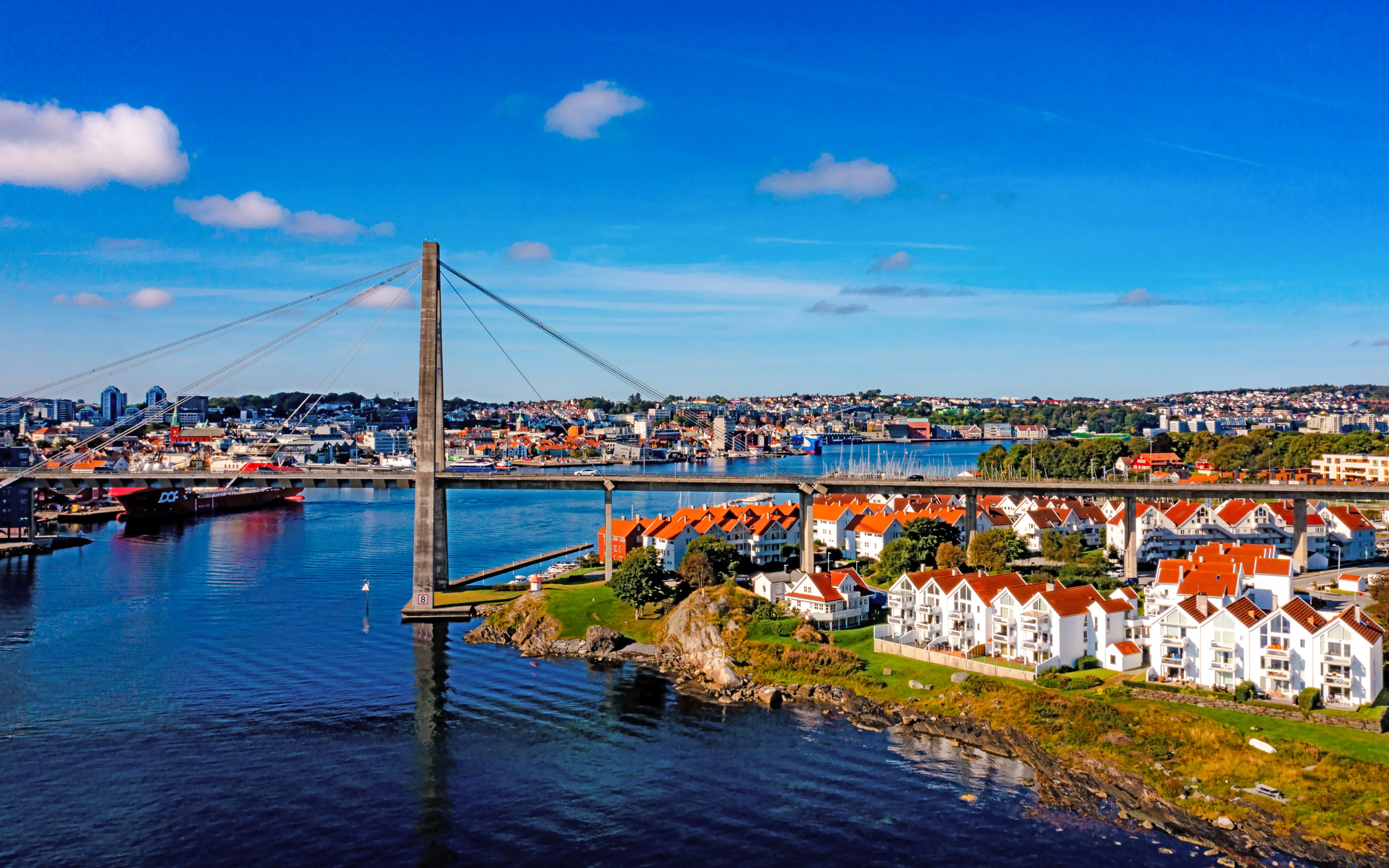 Aerial view of a bridge connecting Stavanger, Norway, with red-roofed houses and waterfront.