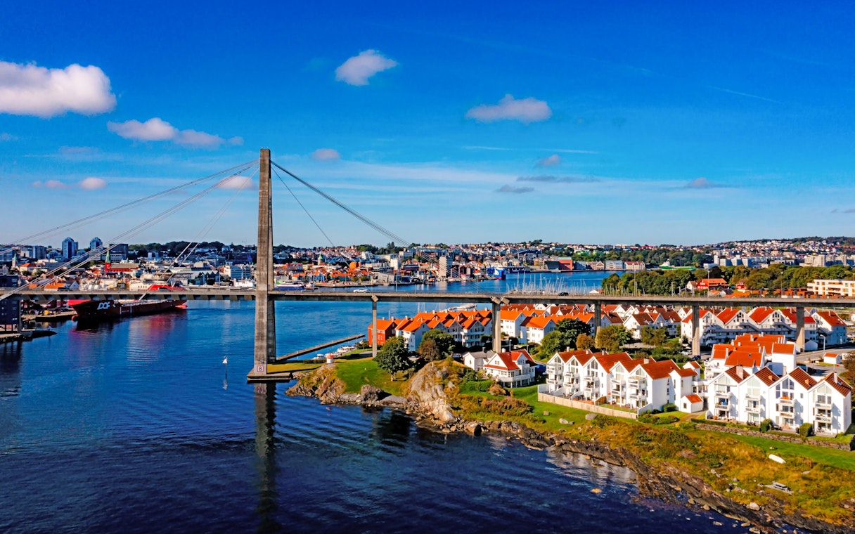 Aerial view of a bridge connecting Stavanger, Norway, with red-roofed houses and waterfront.