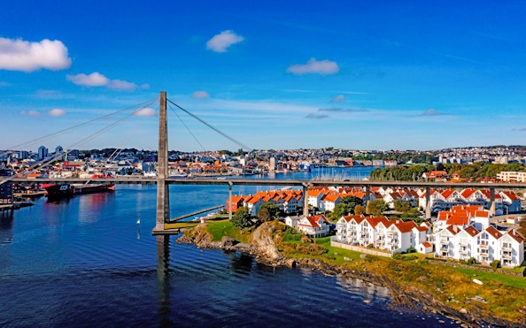 Aerial view of a bridge connecting Stavanger, Norway, with red-roofed houses and waterfront.