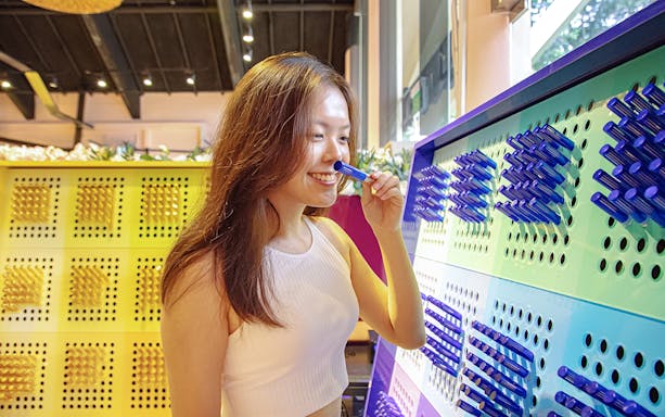 Woman exploring interactive exhibit at Singapore attraction.