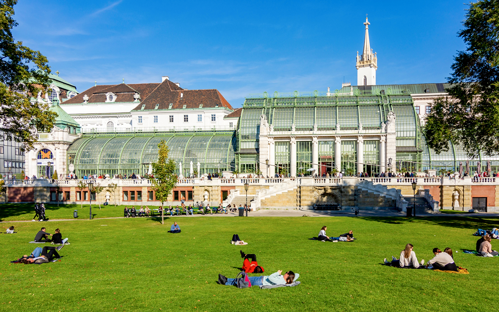 Hofburg Palace gardens with people relaxing on the lawn, Vienna, Austria.