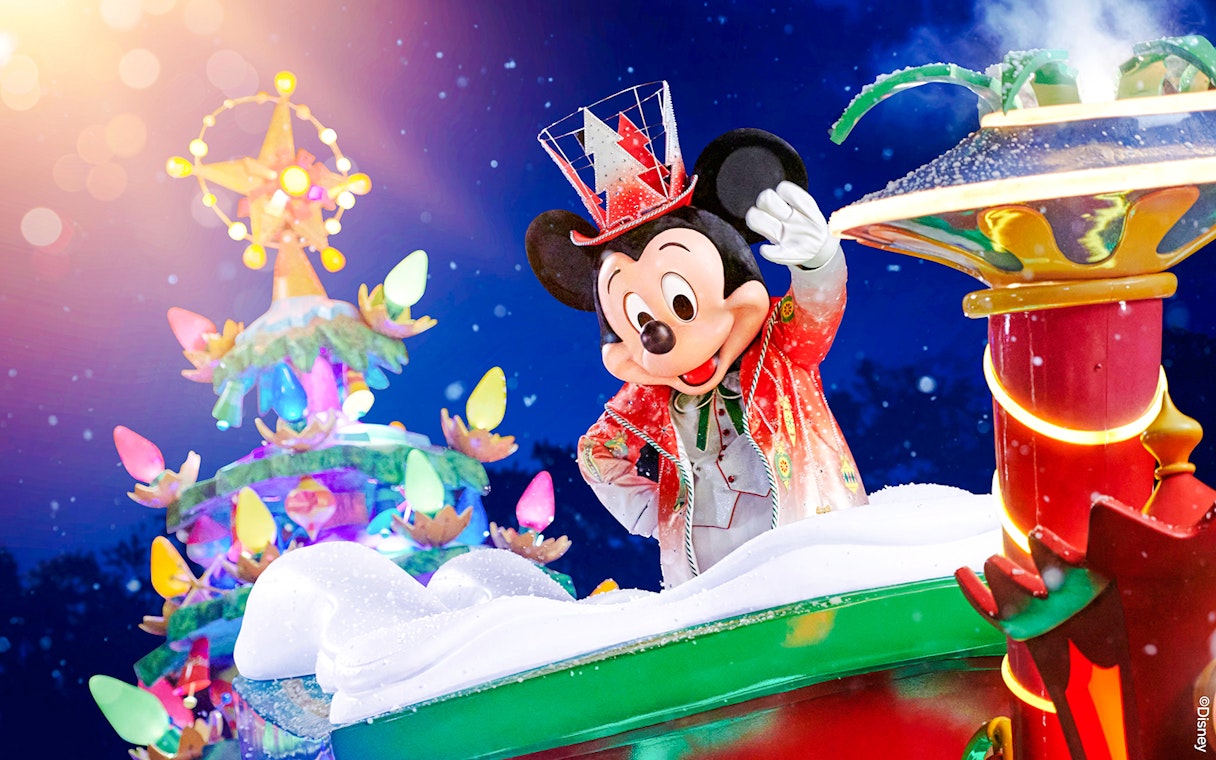 Mickey Mouse in festive attire at Disneyland Christmas 2025 parade.