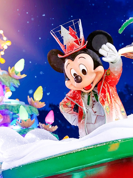 Mickey Mouse in festive attire at Disneyland Christmas 2025 parade.