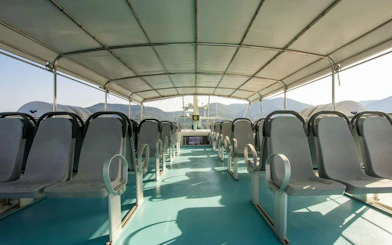 Open-air seating on a cruise boat with mountain views in Cinque Terre.