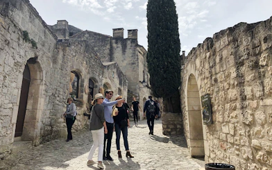 Visitors exploring historic stone streets in Les Baux De Provence, Provence, France.
